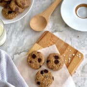 no-bake peanut butter chocolate chip cookies served on a board lined with parchment paper, served with milk and tea.