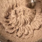 whipped chocolate cream frosting in a large steel bowl.