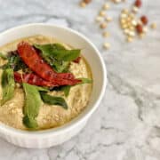 South Indian style peanut chutney served with spiced Indian tempering served in white dish.