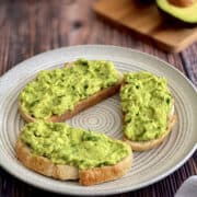 avocado toast using sourdough, fresh ripe avocado in the background.