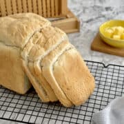 fresh homemade bread on cooling rack, with dairy-free butter cubes in background.