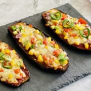 delicious veggie low carb eggplant pizzas served on black board.