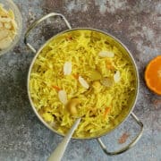 vibrant zarda rice in a serving dish, garnished with flaked almonds.