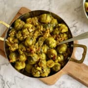 Delicious Indian Brussels sprouts in a serving dish, with a spoon.