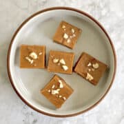 close up of pieces of 3 ingredient peanut butter fudge arranged on a rounded plate.