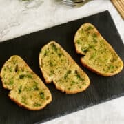 delicious crispy golden sourdough garlic bread, topped with fresh parsley.