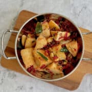 fresh and vibrant masala idli in a serving dish, on a wooden board.