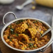 creamy sweetcorn curry in serving dish, garnished with fresh coriander/cilantro.