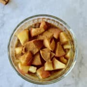 apple and cinnamon chia seed pudding with caramelized apples in glass.