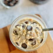 spoon of creamy chocolate chip cookie dough overnight oats, served in a glass.