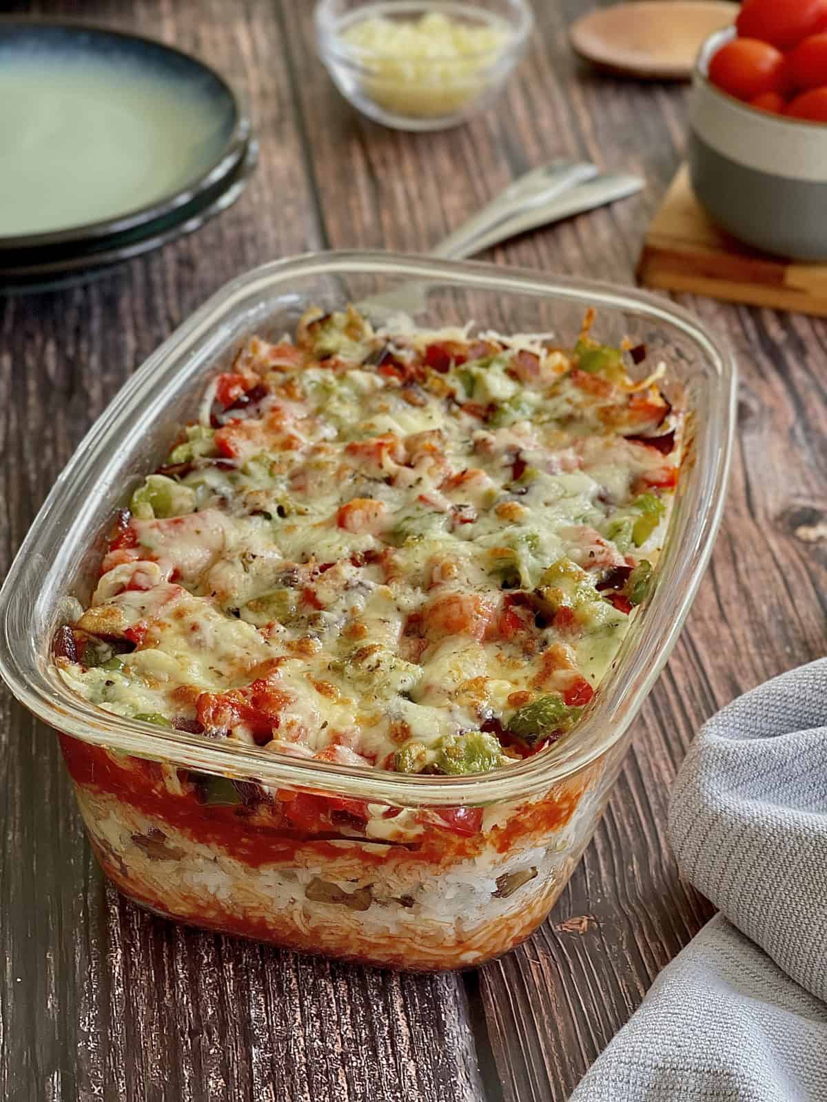 layered Italian rice with mushrooms, vegetables and tomato sauce, topped with melted cheese.