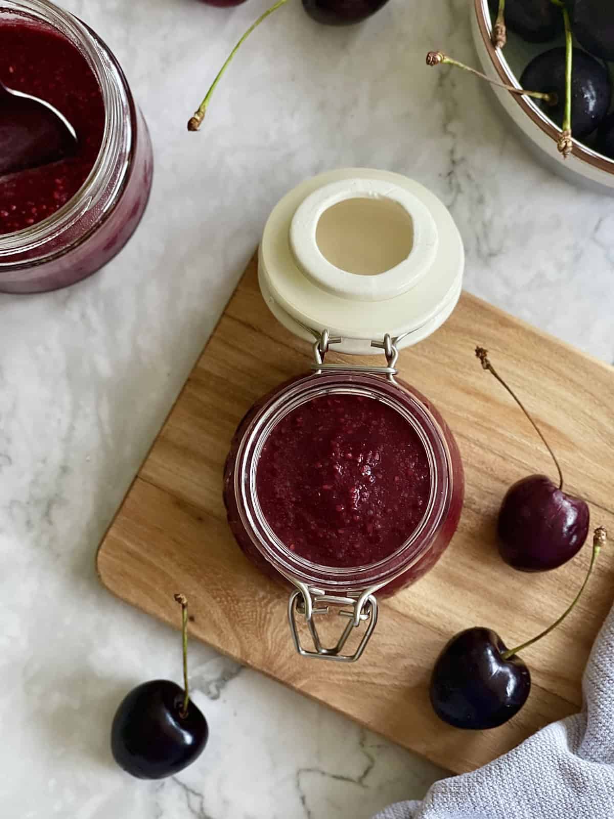 fresh cherry jam in a jar, on a serving board.