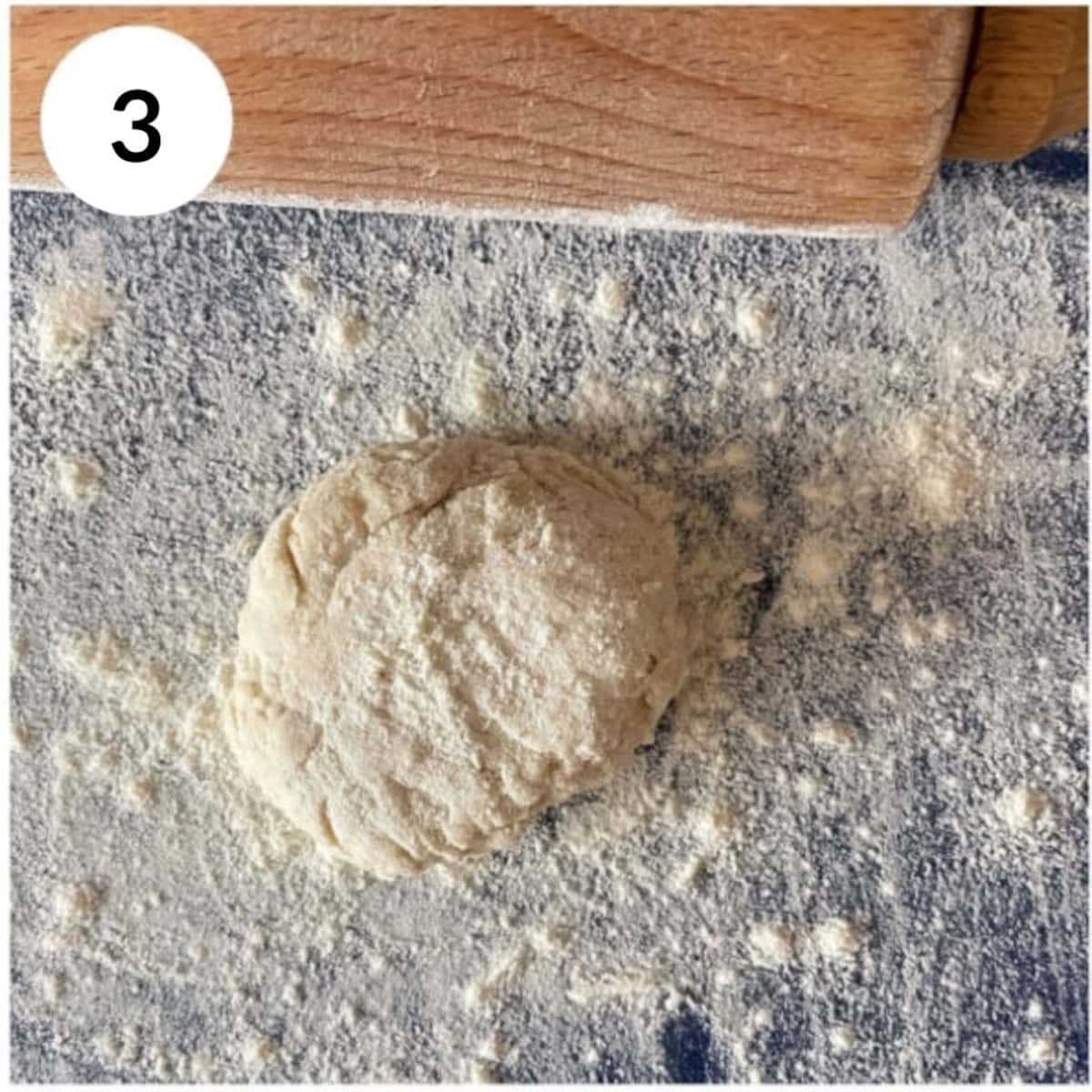 dividing the dough, dusting with flour before rolling into a naan shape.