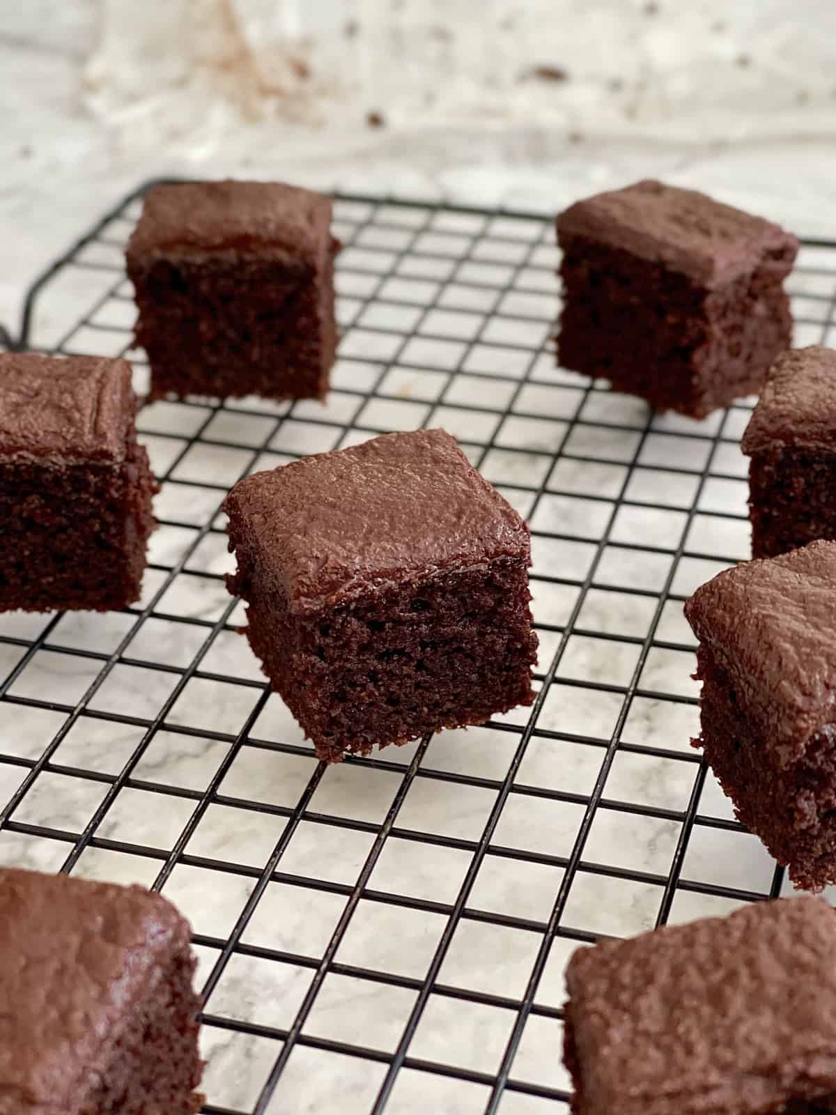 moist and fudgy mini chocolate brownie cakes on a wire rack.