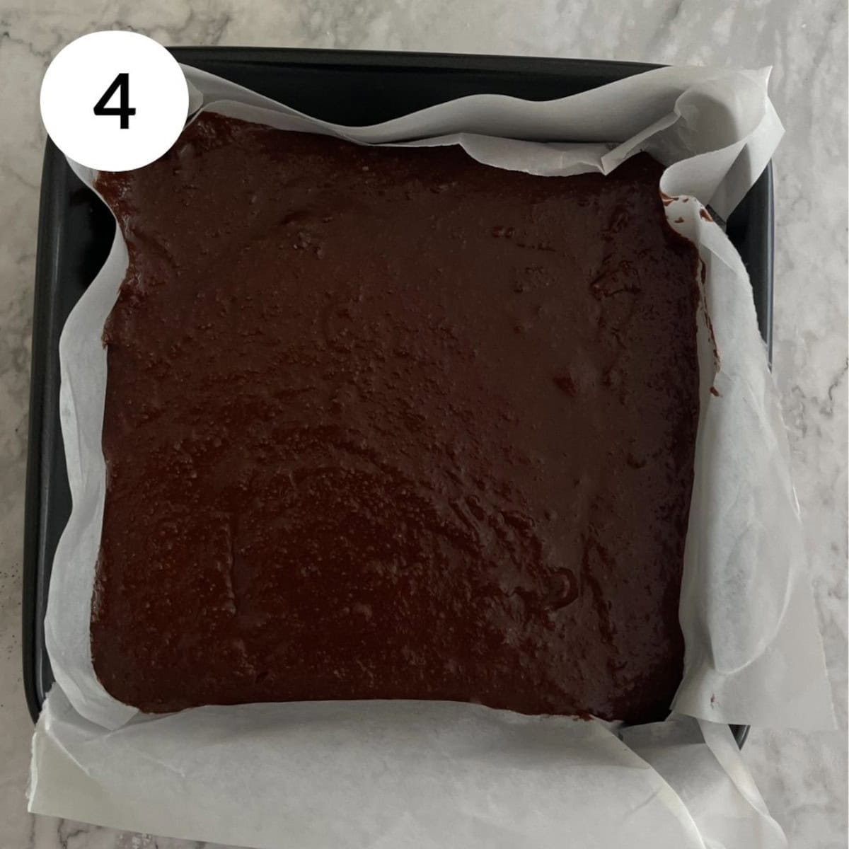 pouring batter into a brownie tin before baking in the air fryer.