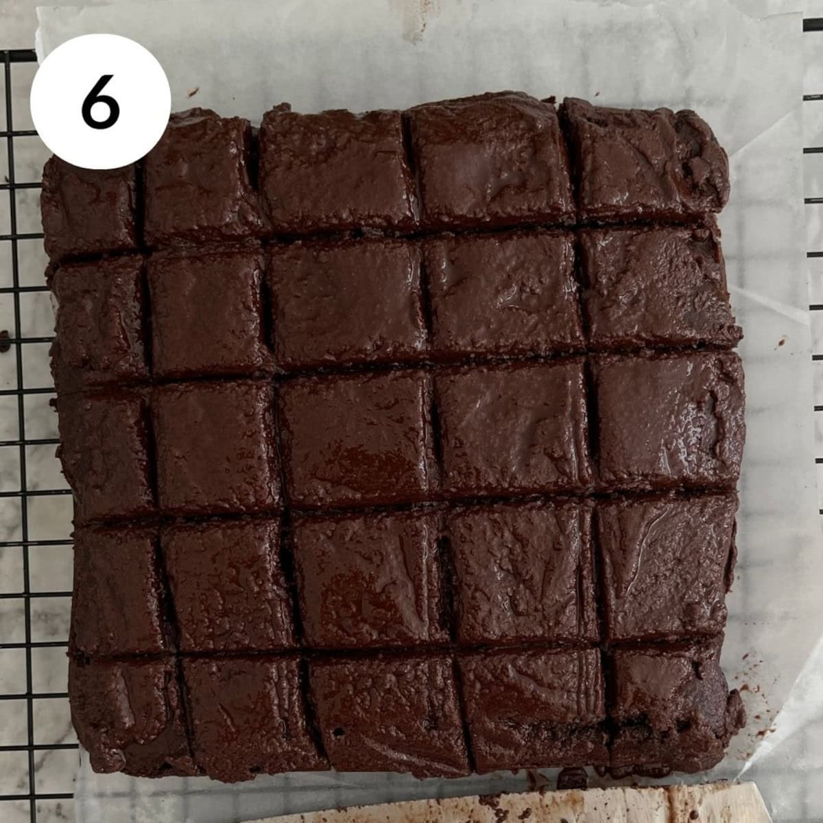 topping the brownie cake with chocolate ganache and cutting into mini squares.