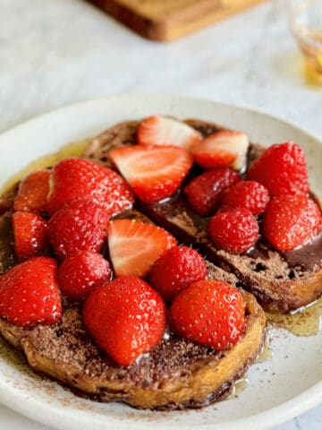 chocolate French toast, with warm maple syrup, a sprinke of cacao powder and and fresh berries.