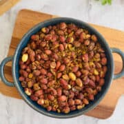 crunchy air fryer masala peanuts served in blue dish, on wooden board.