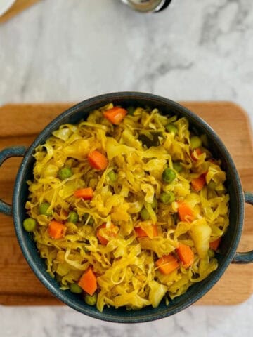 fresh cabbage curry in dark blue dish.