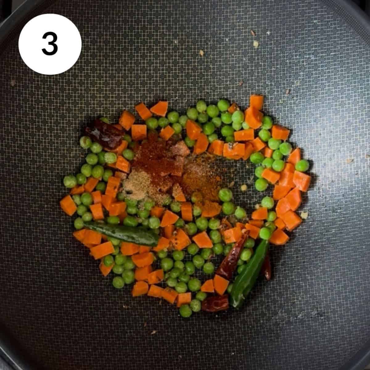 adding spices to the carrots and peas.
