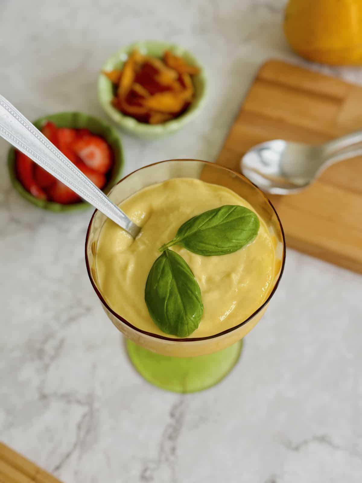 creamy mango cottage cheese pudding topped with fresh basil.