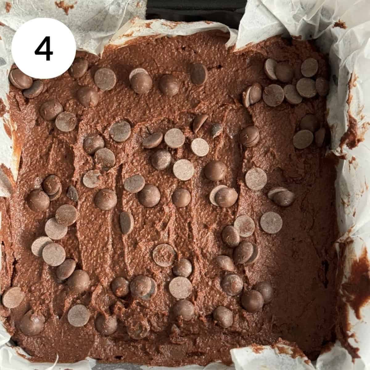 transferring brownie batter into baking tin, topping with chocolate chips and baking.