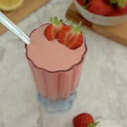 strawberry cottage cheese pudding served in a glass, with strawberries on the side.