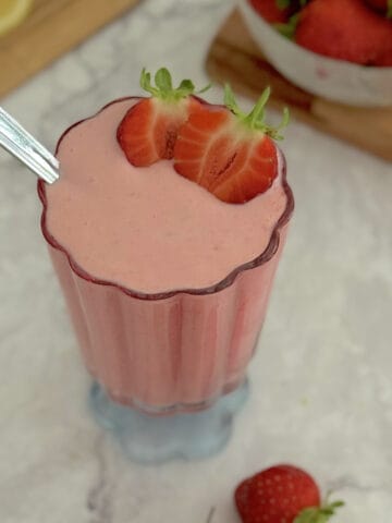 strawberry cottage cheese pudding served in a glass, with strawberries on the side.