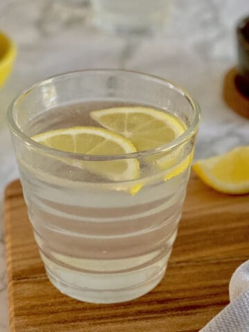 fresh lemon water, with sliced lemon wedges.