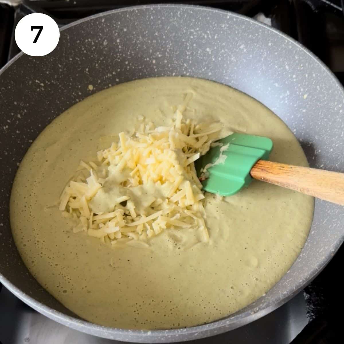 adding blended soup back into pan, with shredded cheese.
